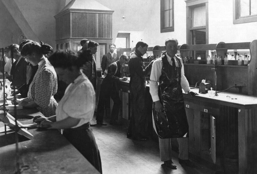 1907 photograph of Chemistry Class. Students working at lab tables in the Chemistry laboratory. [PG1_211-09]