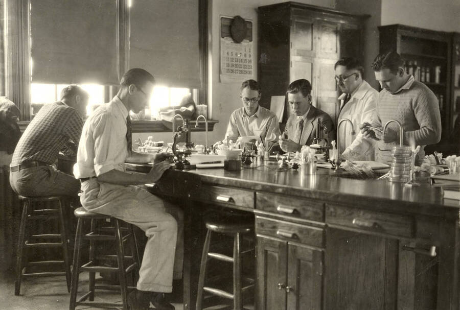1933 photograph of Bacteriology building. Professor and students work in the lab. [PG1_212_06]