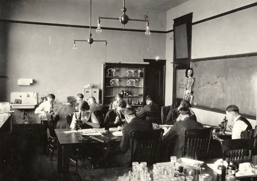 1932 photograph of Zoology building. Students in class work with microscopes. [PG1_214_01]