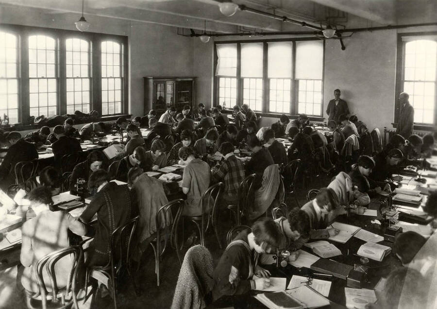 1928 photograph of Zoology building. Students study in class. [PG1_214_02]
