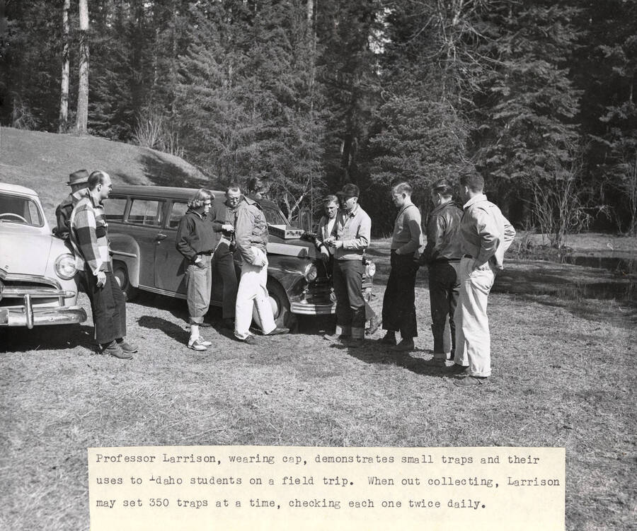1951 photograph of Zoology building. Professor demonstrates the use of small traps to his students at the start of a field trip. [PG1_214_16]