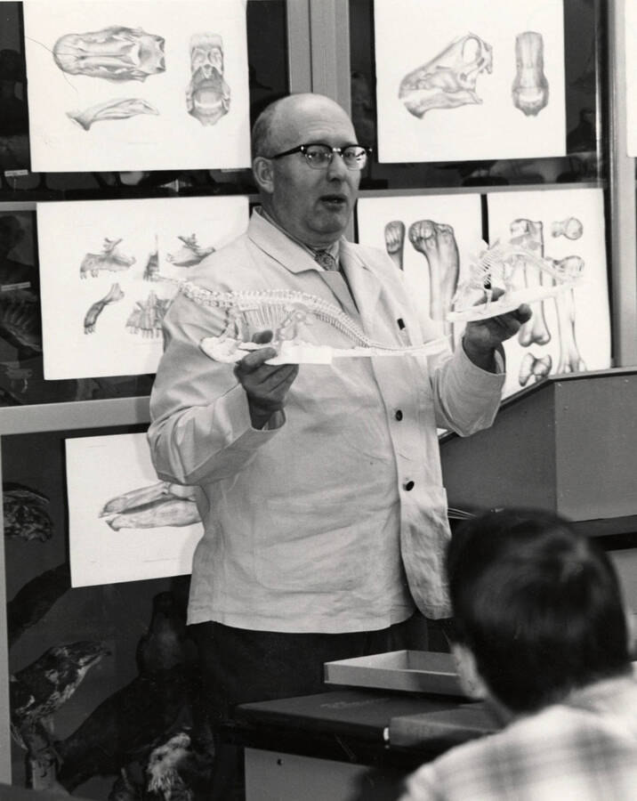1965 photograph of Zoology building. Professor holds a small skeleton while giving a lecture. [PG1_214_27d]