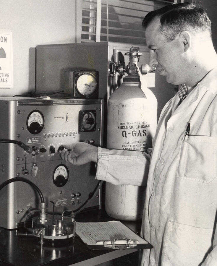 1959 photograph of Agricultural chemistry building. Professor adjusts equipment. [PG1_216_15]