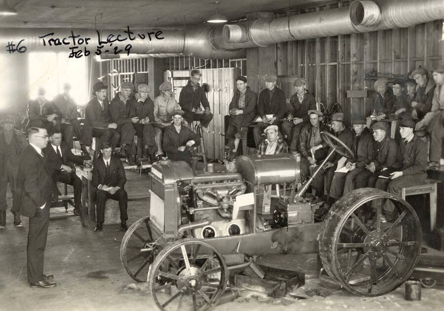 1929-02-05 photograph of Agricultural engineering building. Professor lectures students in the engineering shop. [PG1_217_02]