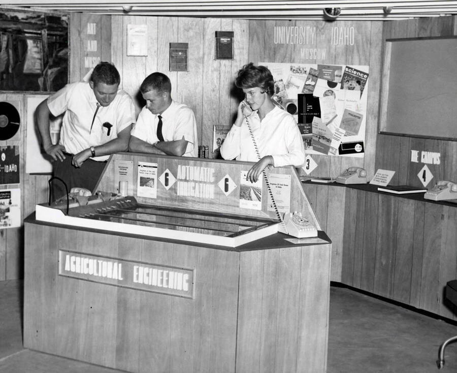 1952 photograph of Agricultural engineering building. Students stand behind an agricultural engineering display. [PG1_217_12]