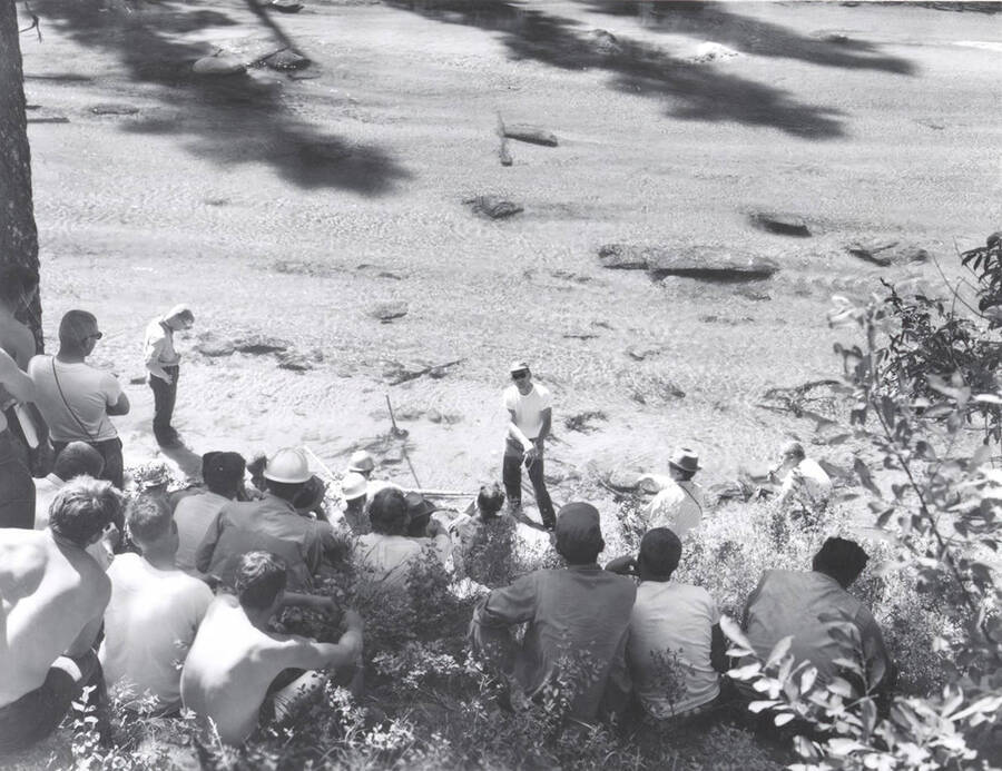 1966 photograph of College of Forestry. Students sitting on a hillside overlooking a lake during the forestry summer camp. Also print. Donor: Fred Johnson. [PG1_218-69b]