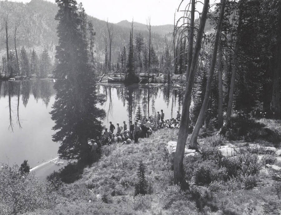 1966 photograph of College of Forestry. Students sitting on a hillside overlooking a lake during the forestry summer camp. Also print. Donor: Fred Johnson. [PG1_218-69d]