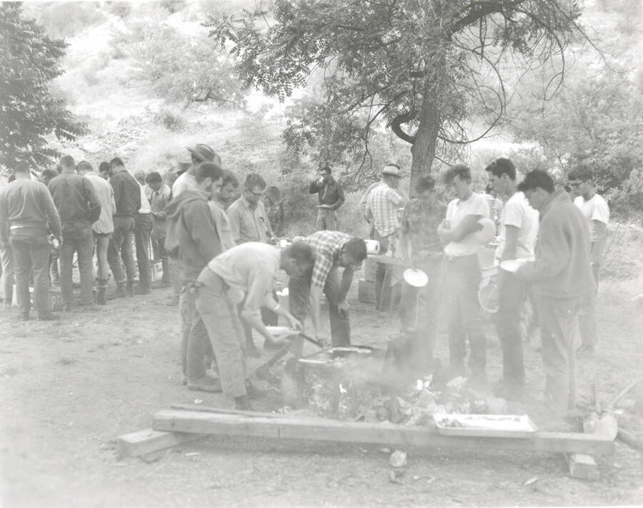 1968 photograph of College of Forestry. Students gather around a campfire during the forestry summer camp. Also print. Donor: Fred Johnson. [PG1_218-70b]