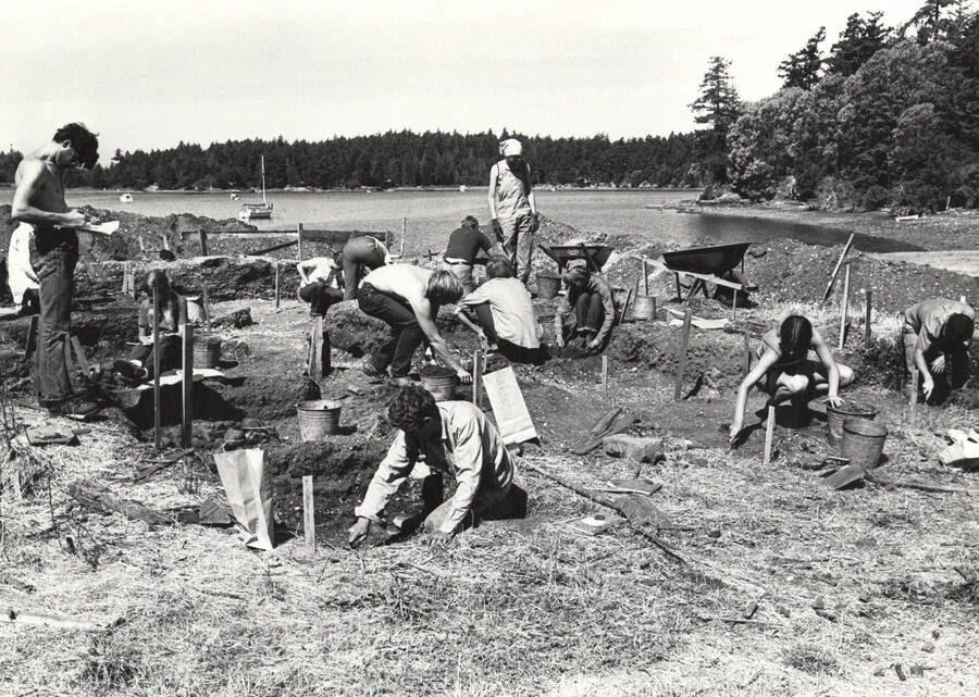 1970-07-03 photograph of College of Forestry. Students excavating test pits near a lake during the forestry summer camp. Donor: Fred Johnson. [PG1_218-72a]