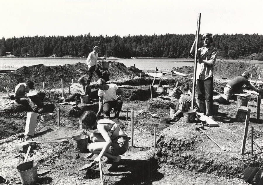 1970-07-03 photograph of College of Forestry. Students excavating test pits near a lake during the forestry summer camp. Donor: Fred Johnson. [PG1_218-72b]