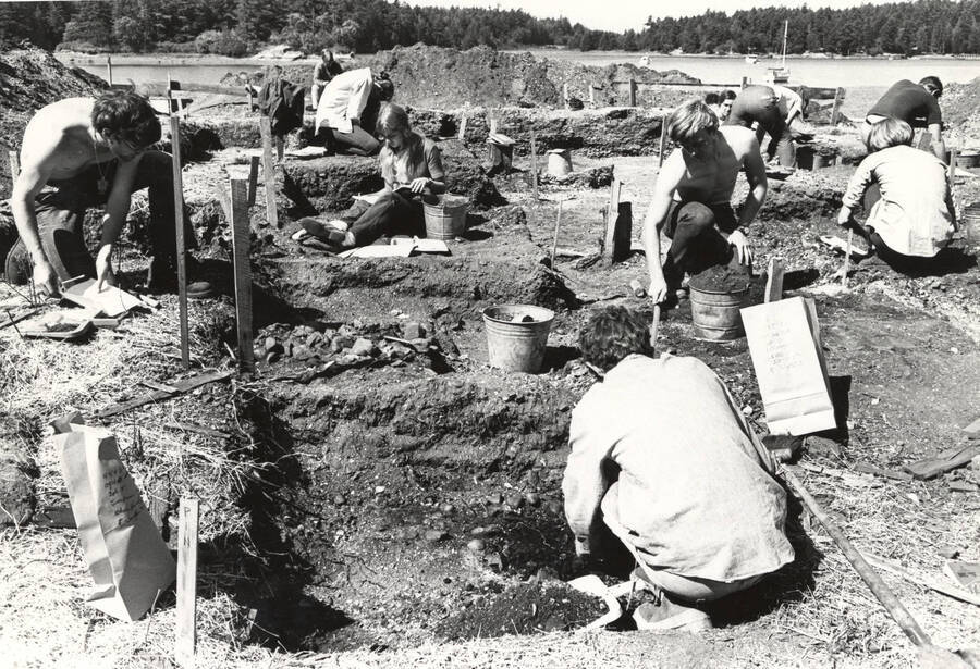 1970-07-03 photograph of College of Forestry. Students excavating test pits near a lake during the forestry summer camp. Donor: Fred Johnson. [PG1_218-72c]
