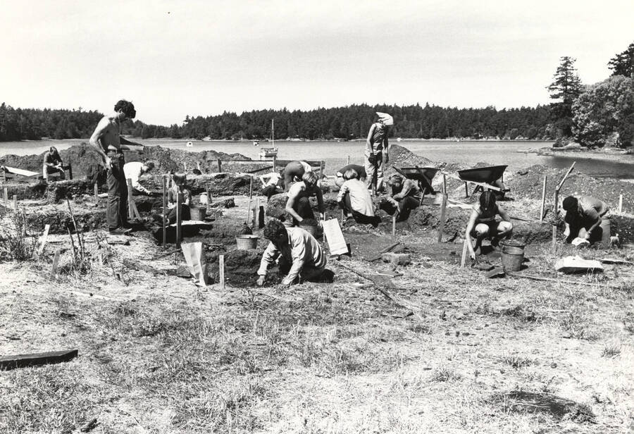 1970-07-03 photograph of College of Forestry. Students excavating test pits near a lake during the forestry summer camp. Donor: Fred Johnson. [PG1_218-72d]