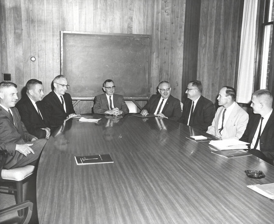 1963-04-19 photograph of College of Forestry. D. Haynes, Bud Jones, Fred Dickinson, Ernest Wohletz, Bob Olin, Edgar Grahn, John Howe, and Dick Just sitting around a polished conference table. Donor: Graduate School. [PG1_218-30]