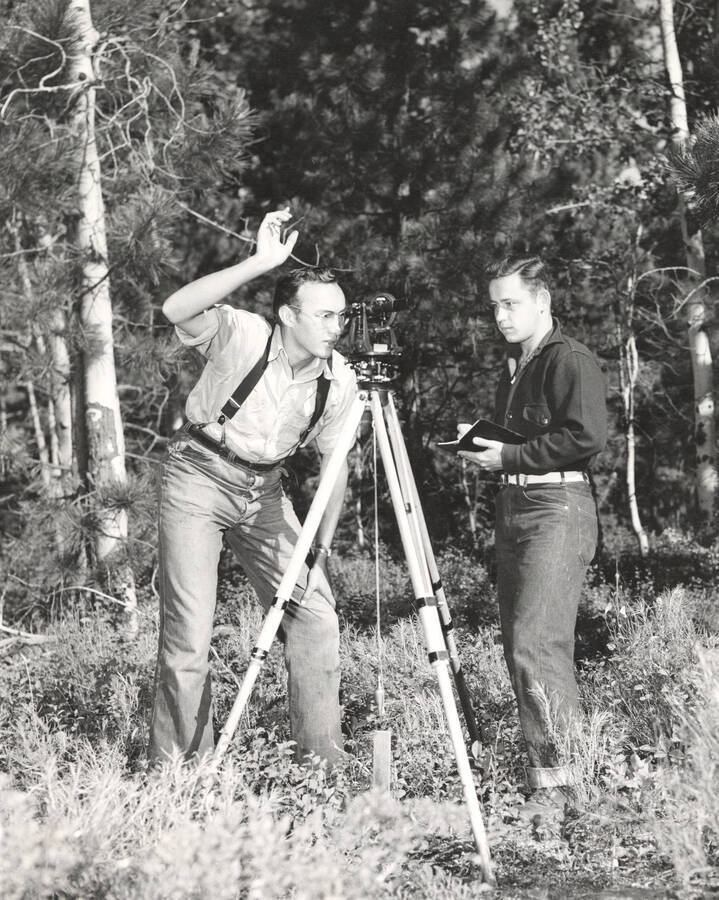 1951 photograph of College of Forestry. Robert McMahon and James Kuechmann surverying in the forest. Donor: Publications Dept. [PG1_218-33]