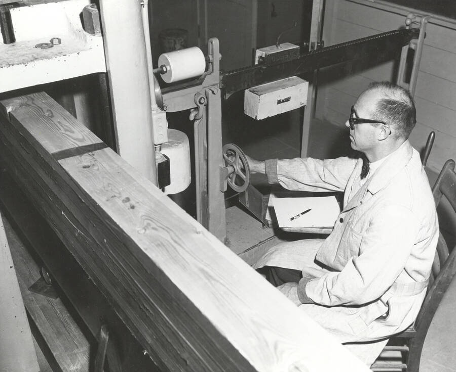 1960 photograph of College of Forestry. Arland D. Hofstrand using a machine to test beams. Donor: Publications Dept. [PG1_218-40]