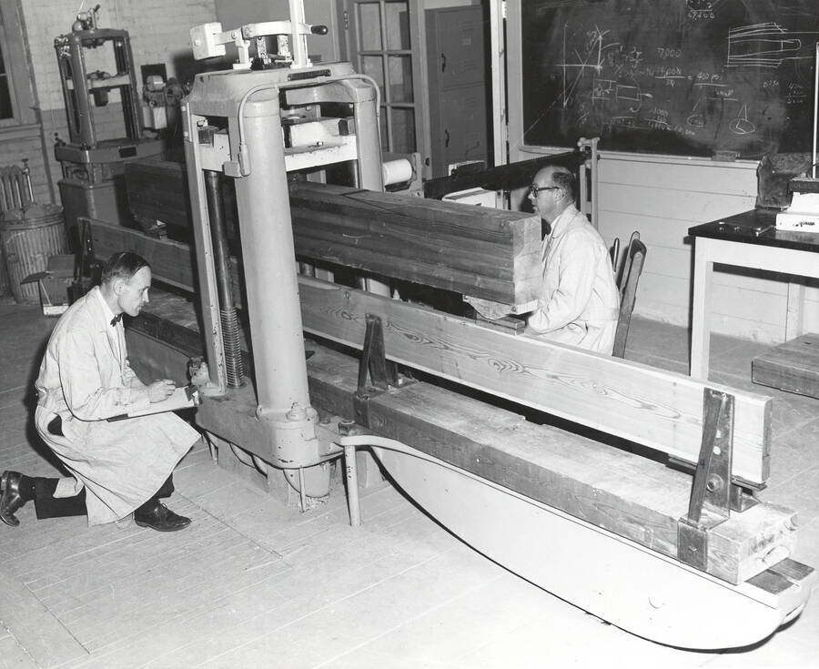1961 photograph of College of Forestry. John P. Howe and Arland D. Hofstrand use a machine to test beams. Donor: Publications Dept. [PG1_218-41]