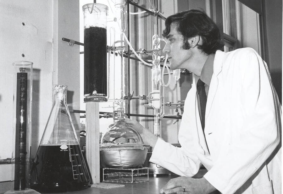1970 photograph of College of Forestry. Researcher Roy Adams uses lab equipment to perform a chemical test on red cedar bark. Donor: Publications Dept. [PG1_218-44]