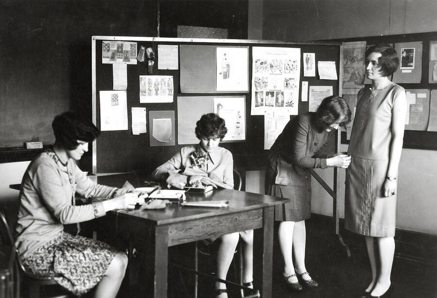 1927 photograph of Home Economics. Students work together to make dresses in class. [PG1_221-012]