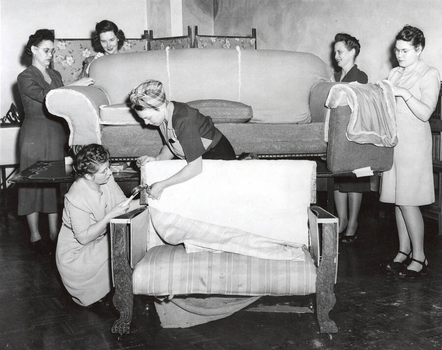 1945 photograph of Home Economics. Students upholster a chair and a couch during class. [PG1_221-019]