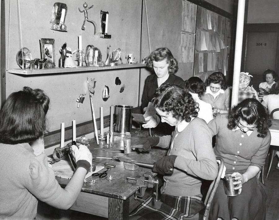 1942 photograph of Home Economics. Students Dorothy Wiley, Julein Paulson, Erma Smith, and Florence Marshall during tin work class. [PG1_221-024]
