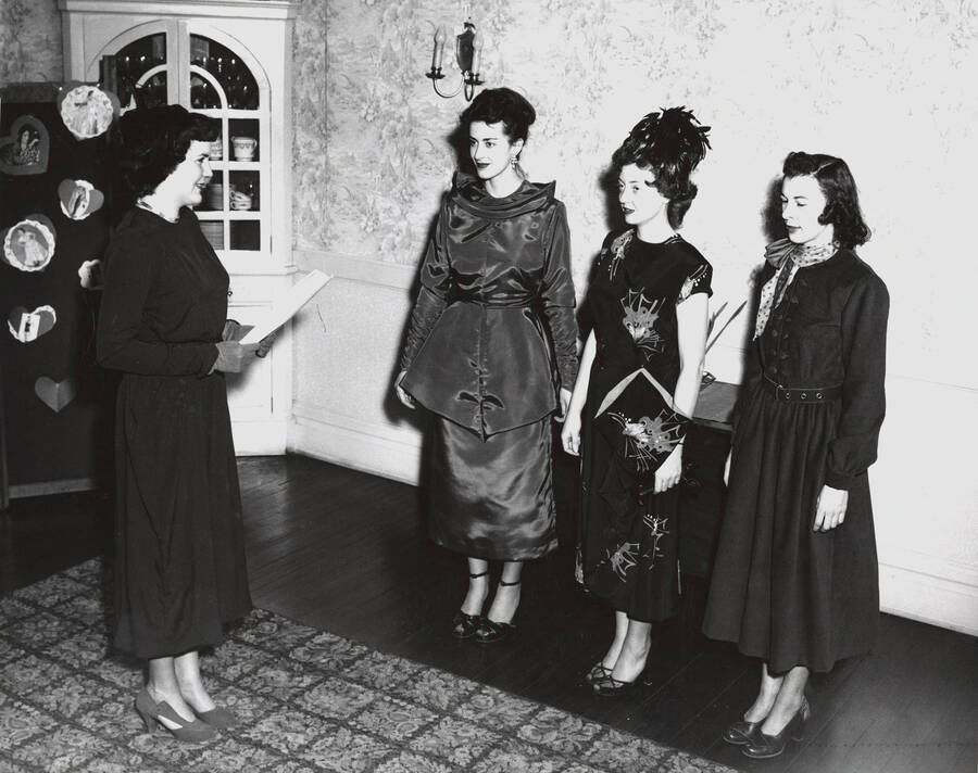 1952 photograph of Home Economics. Three students modeling dresses talking to a commentator during a fashion show. [PG1_221-030]
