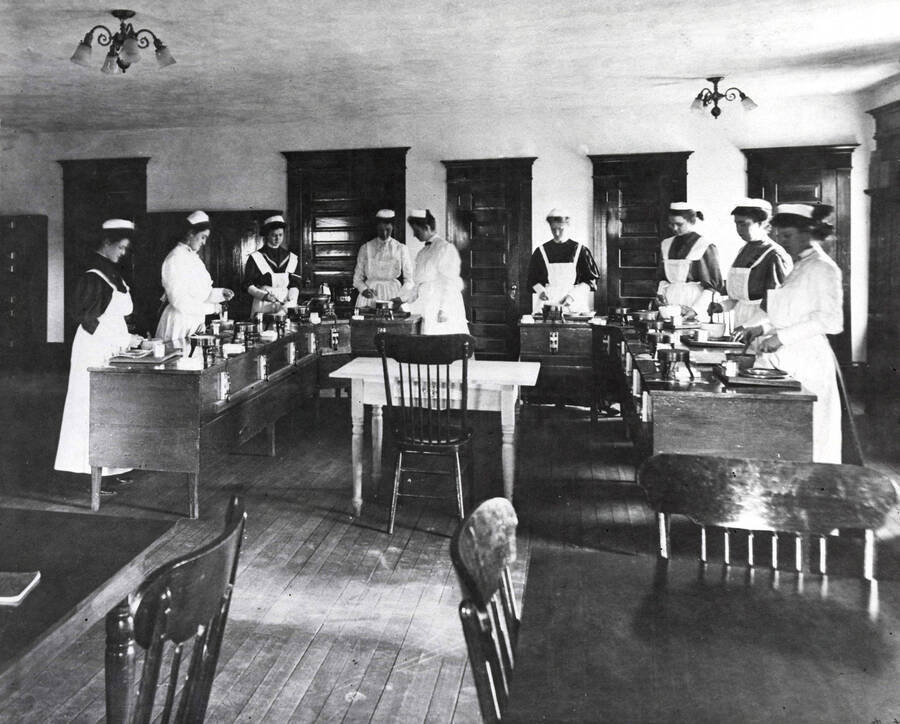 1902 photograph of Home Economics. Students participate in cooking class in Ridenbaugh Hall. [PG1_221-004]