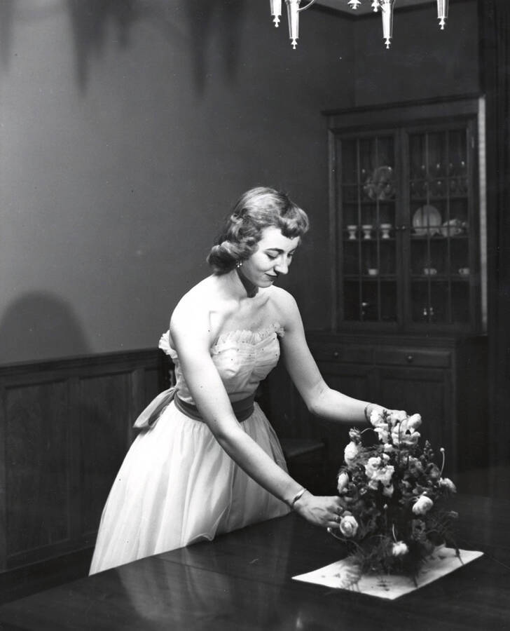 1950 photograph of Home Economics. A student arranges a flower centerpiece. Donor: Publications Dept. [PG1_221-040]