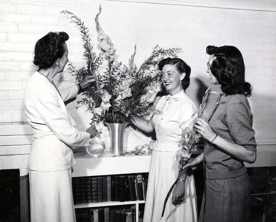 1948 photograph of Home Economics. Miss Marian Featherstone and two students arrange flowers. Donor: Publications Dept. [PG1_221-042]