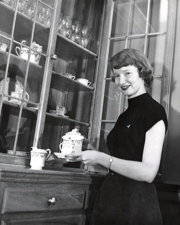 1954 photograph of Home Economics. Patricia Stewart demonstrates tea pouring. Donor: Publications Dept. [PG1_221-045]