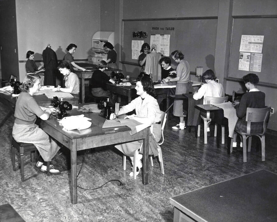 1942 photograph of Home Economics. Students operating sewing machines during sewing class. Donor: Publications Dept. [PG1_221-051]