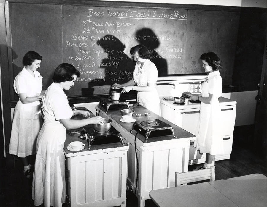1942 photograph of Home Economics. Students cooking Bean Soup Dubois Recipe. Donor: Publications Dept. [PG1_221-053]