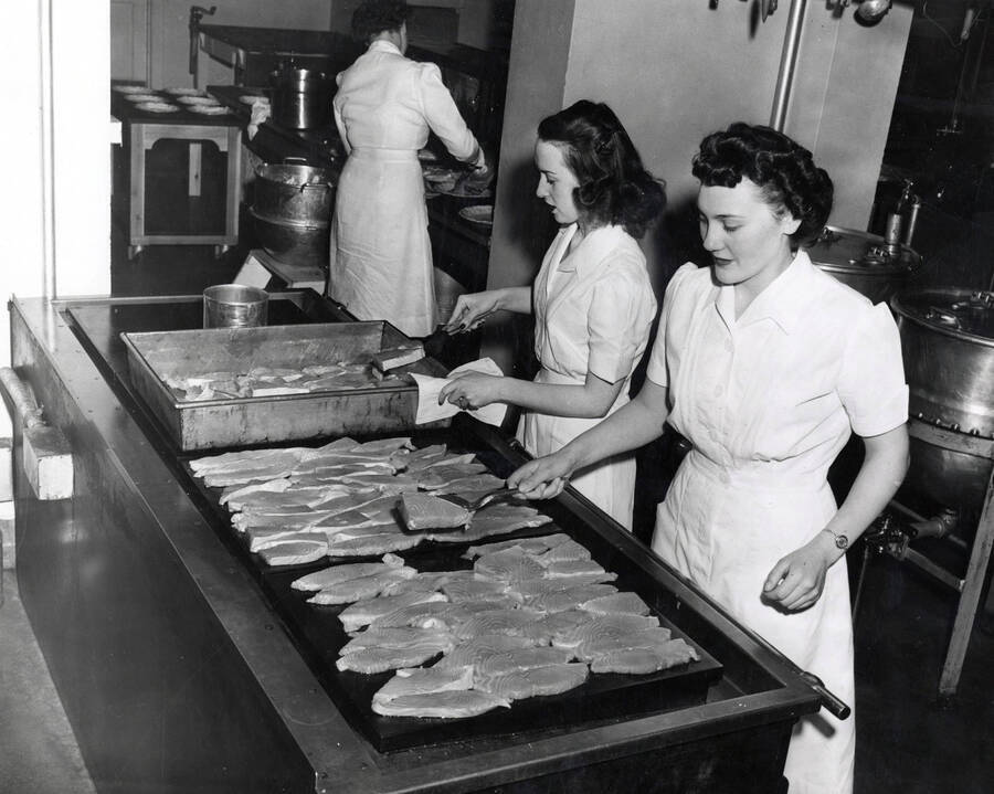 1955 photograph of Home Economics. Students cooking on a large griddle during class. Donor: Publications Dept. [PG1_221-057]