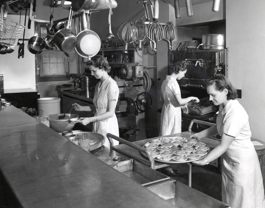 1955 photograph of Home Economics. Students cooking during class. Donor: Publications Dept. [PG1_221-058]