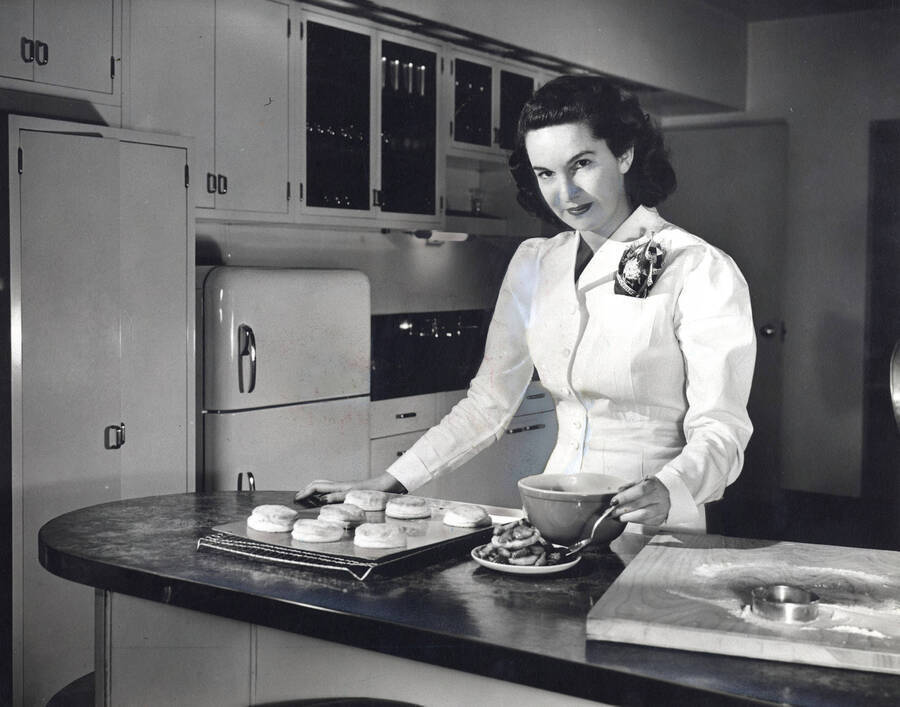1955 photograph of Home Economics. A student shows a tray of english muffins. Donor: Publications Dept. [PG1_221-059]