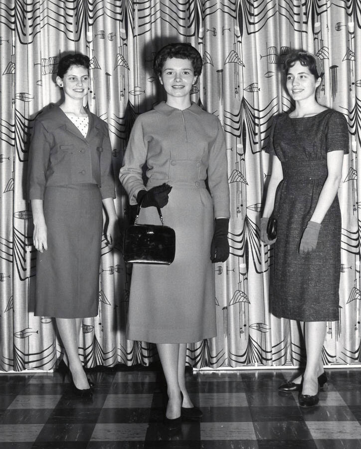 1963 photograph of Home Economics. Three students modeling dresses. Donor: Publications Dept. [PG1_221-073]