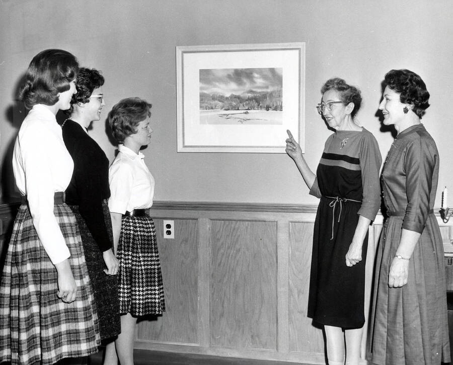 1966 photograph of Home Economics. Students with Marion Featherstone and Gladys Bellinger examine a mounted photograph. Donor: Publications Dept. [PG1_221-080]