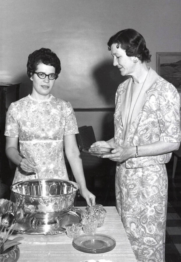 1964 photograph of Home Economics. A student serves punch from a silver bowl. Donor: Publications Dept. [PG1_221-081]