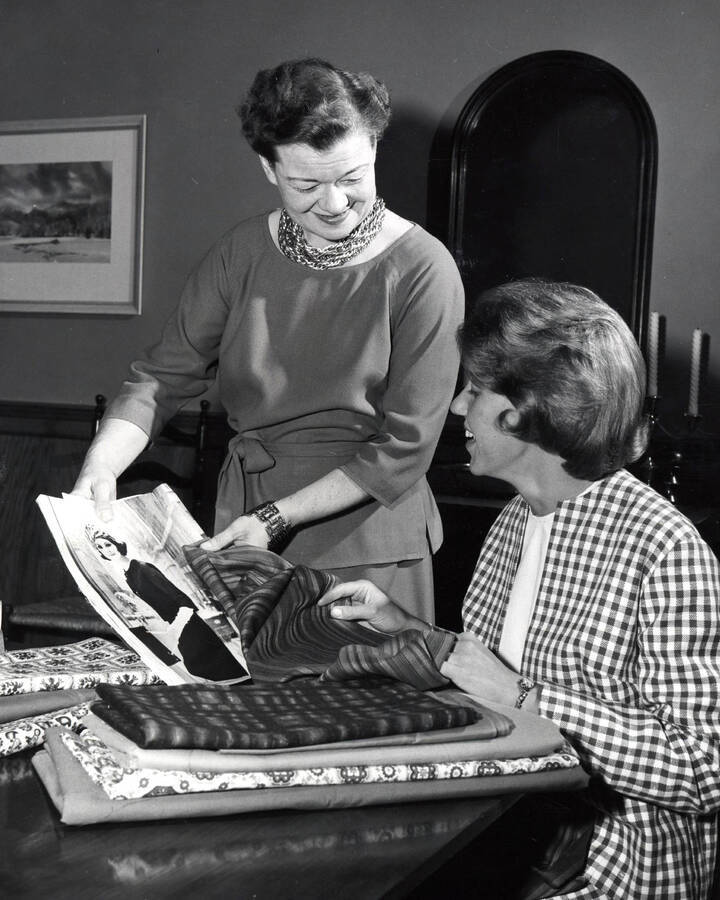1964 photograph of Home Economics. Ruth B. Ridenour discusses fabrics with Karyl Lambeth. [PG1_221-087]