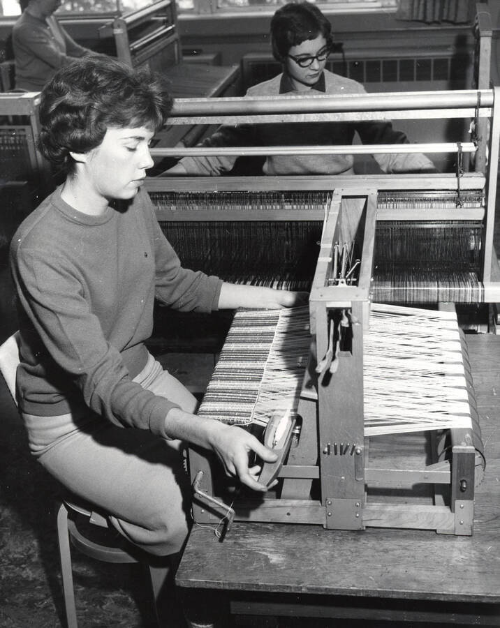 1960 photograph of Home Economics. Students working at looms during weaving class. [PG1_221-089]