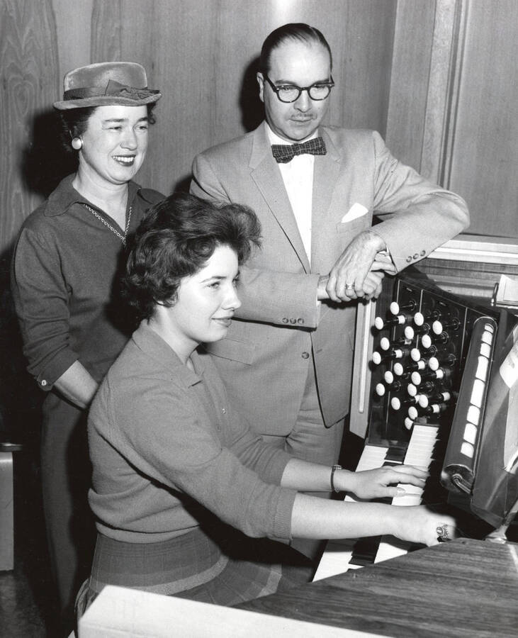 1960 photograph of Music Department. Organ student Kathleen Irwin, her mother Mrs. Claude Irwin, and professor Hall M. Macklin at an organ keyboard. [PG1_222-017]