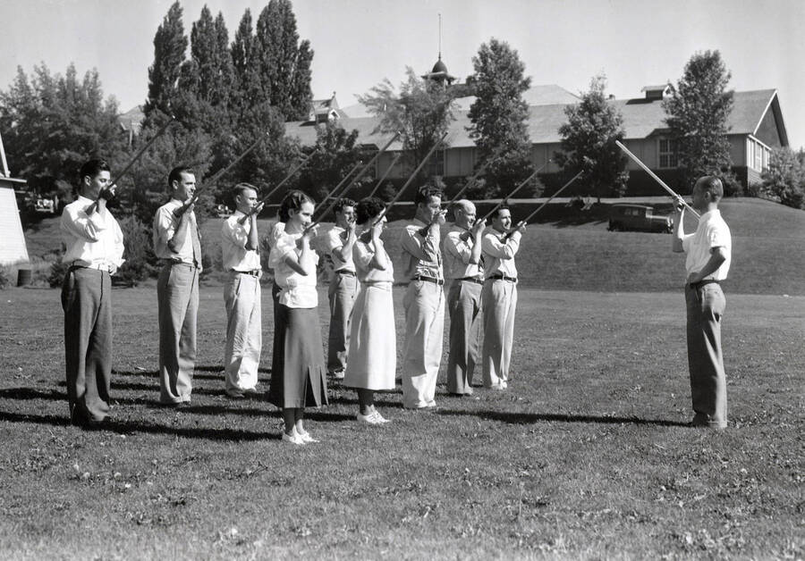 1934 photograph of Music Department. Student marching band practices conducting during summer music class. [PG1_222-002]