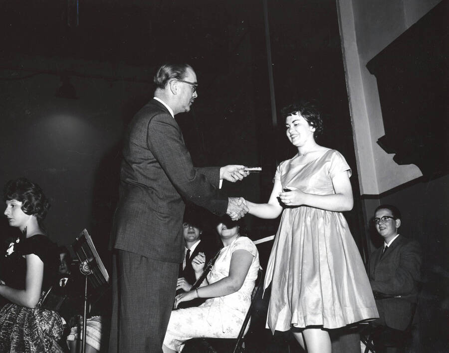 1951 photograph of Music Department. Hall Macklin presenting a summer music camp award to Ann Williams. Donor: Publications Dept. [PG1_222-023]