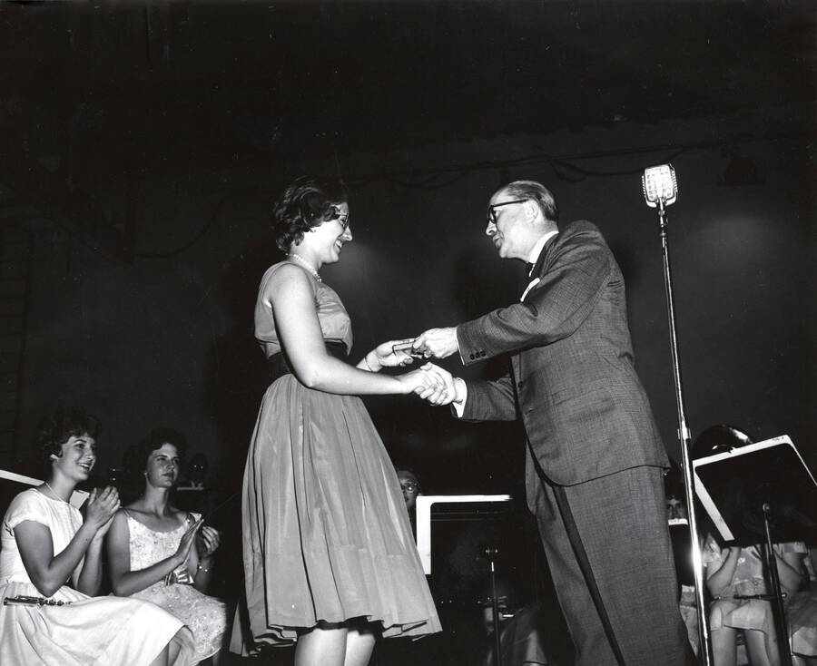 1951 photograph of Music Department. Hall Macklin presenting a summer music camp award to Kay Hostetler. Donor: Publications Dept. [PG1_222-027]