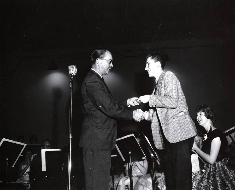 1951 photograph of Music Department. Hall Macklin presenting a summer music camp award to Todd Bake. Donor: Publications Dept. [PG1_222-029]