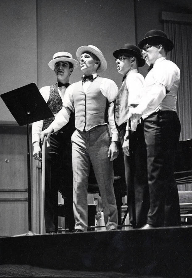 1961 photograph of Music Department. Barbershop quartet Pat Freeman, John Pederson, Larry Gee, and Alan Hamilton performing. Donor: Publications Dept. [PG1_222-033]