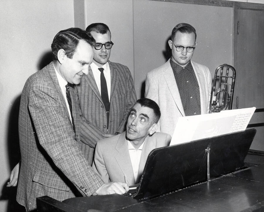 1951 photograph of Music Department. William Billingsley and Warren Bellis at piano with students. Donor: Publications Dept. [PG1_222-050]