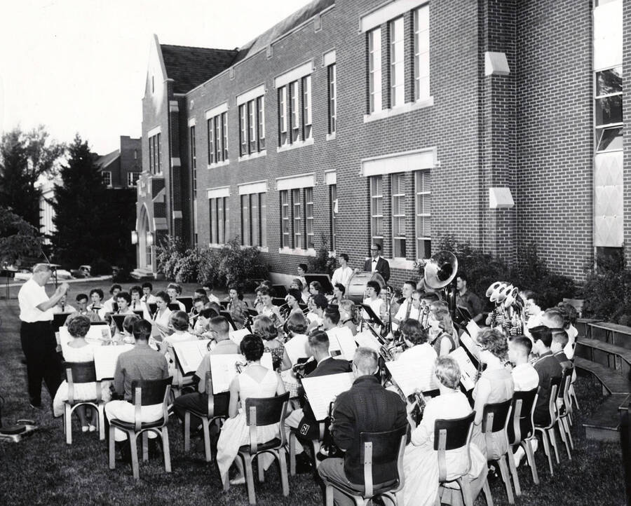 1951 photograph of Music Department. Outdoor rehersal of the summer school band in front of the School of Music building. Donor: Publications Dept. [PG1_222-052]