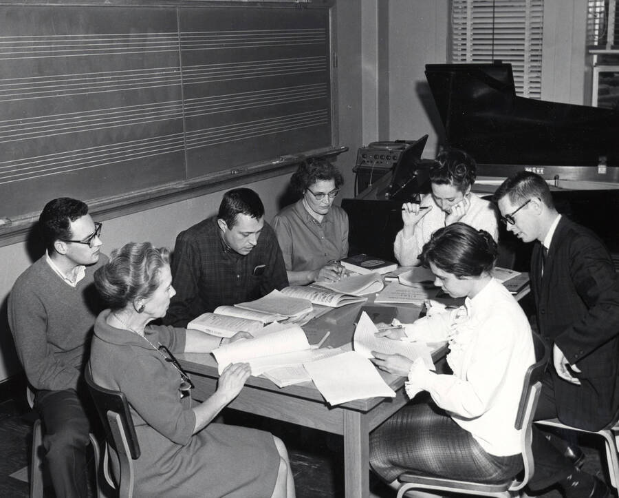 1950 photograph of Music Department. Students studying in front of a blackboard during music class. Donor: Publications Dept. [PG1_222-056]