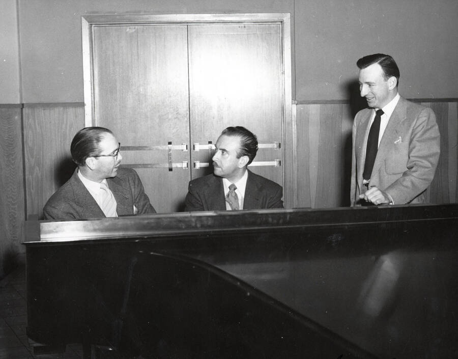 1950 photograph of Music Department. Hall Macklin, Glen Lockery and an unidentified man sit behing a piano. Donor: Publications Dept. [PG1_222-072]