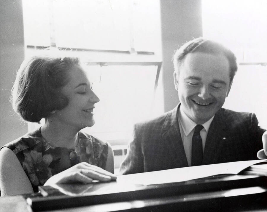 1963 photograph of Music Department. Paula and David Tyler at a piano. Donor: Publications Dept. [PG1_222-078]